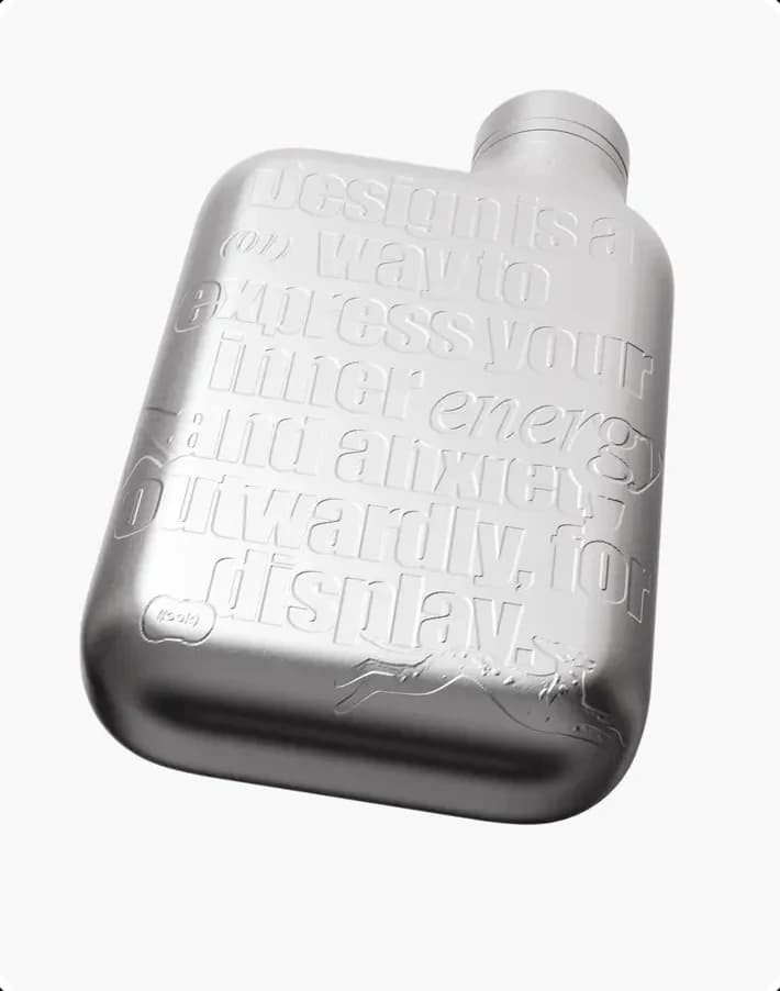 A metal flask with embossed lettering — a studio object